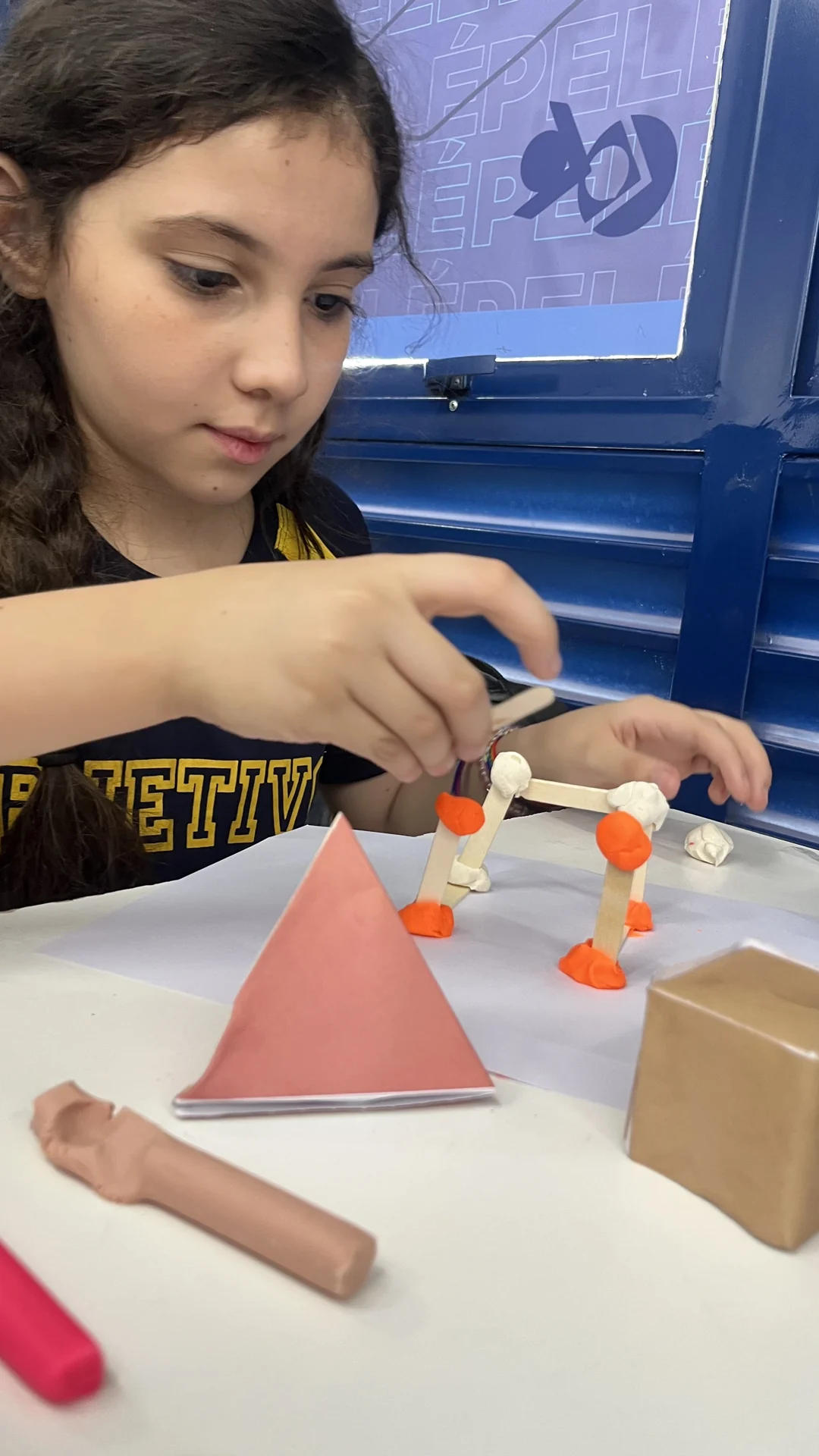 Aluna experimentando e aprendendo em atividade do Objetivo